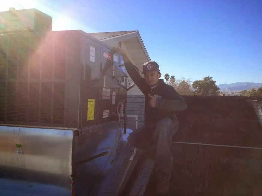 HVAC technician performing Heat Pump Repair on a rooftop unit in Valley Center